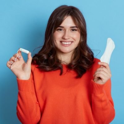 pleasant-looking-woman-casual-attire-standing-with-tampon-sanitary-napkin-hands_176532-14412